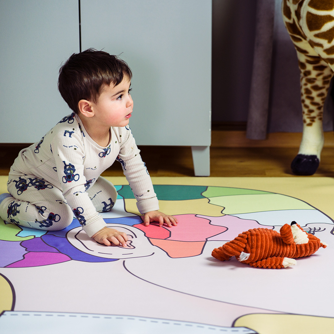Ett barn som leker på en färgglad lekmatta.
